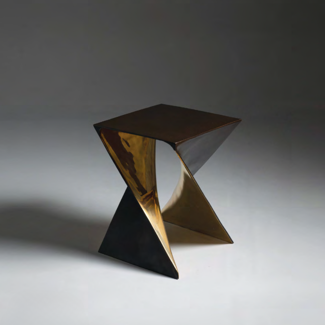 Modern bronze stool with a geometric design on a gray background