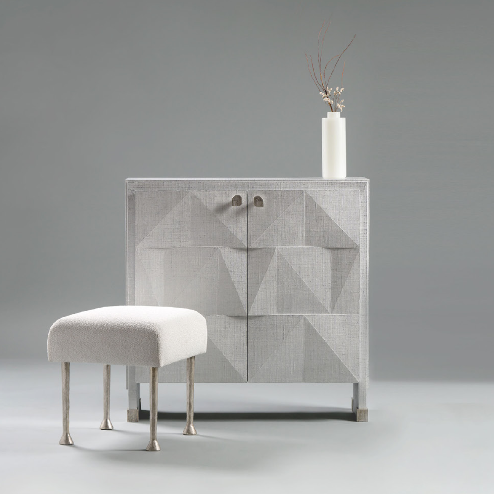 Modern cabinet with geometric design and matching ottoman on a gray background