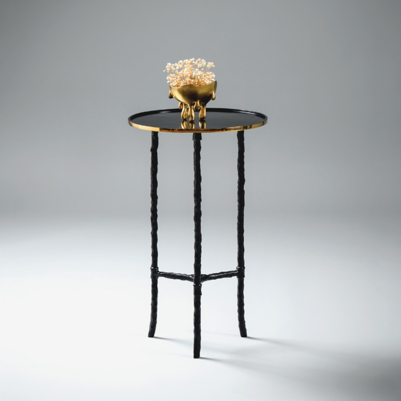 Small round table with a decorative bowl on a gray background